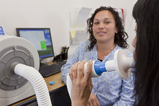 Patient performs lung function test at UC Irvine's Occupational and Environmental Health Clinic.